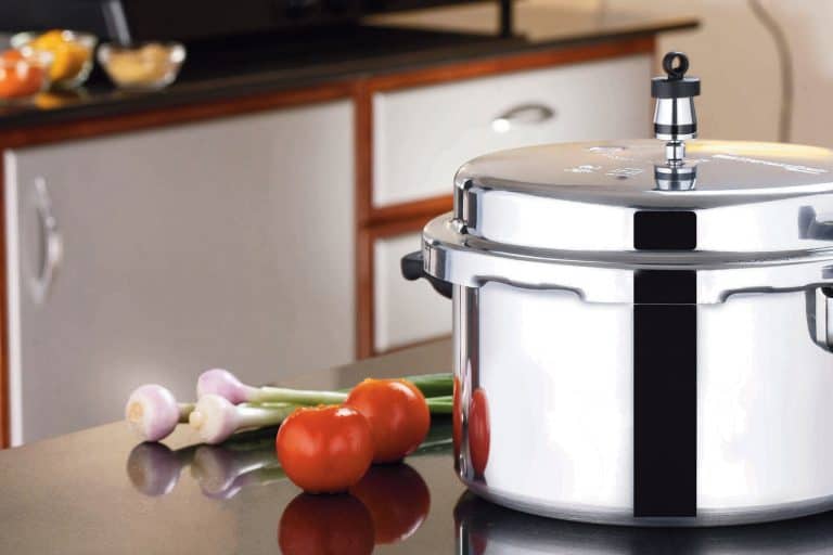 Stainless Steel Pressure Cooker in kitchen background, Does A Pressure Cooker Reduce Liquid?