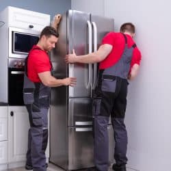 Two male move modern steel refrigerator in kitchen, Does A Refrigerator Typically Stay With The House?