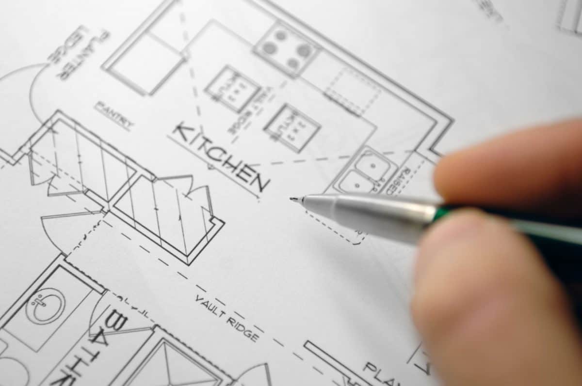 selective focus image of architectural drawings and hand holding mechanical pencil