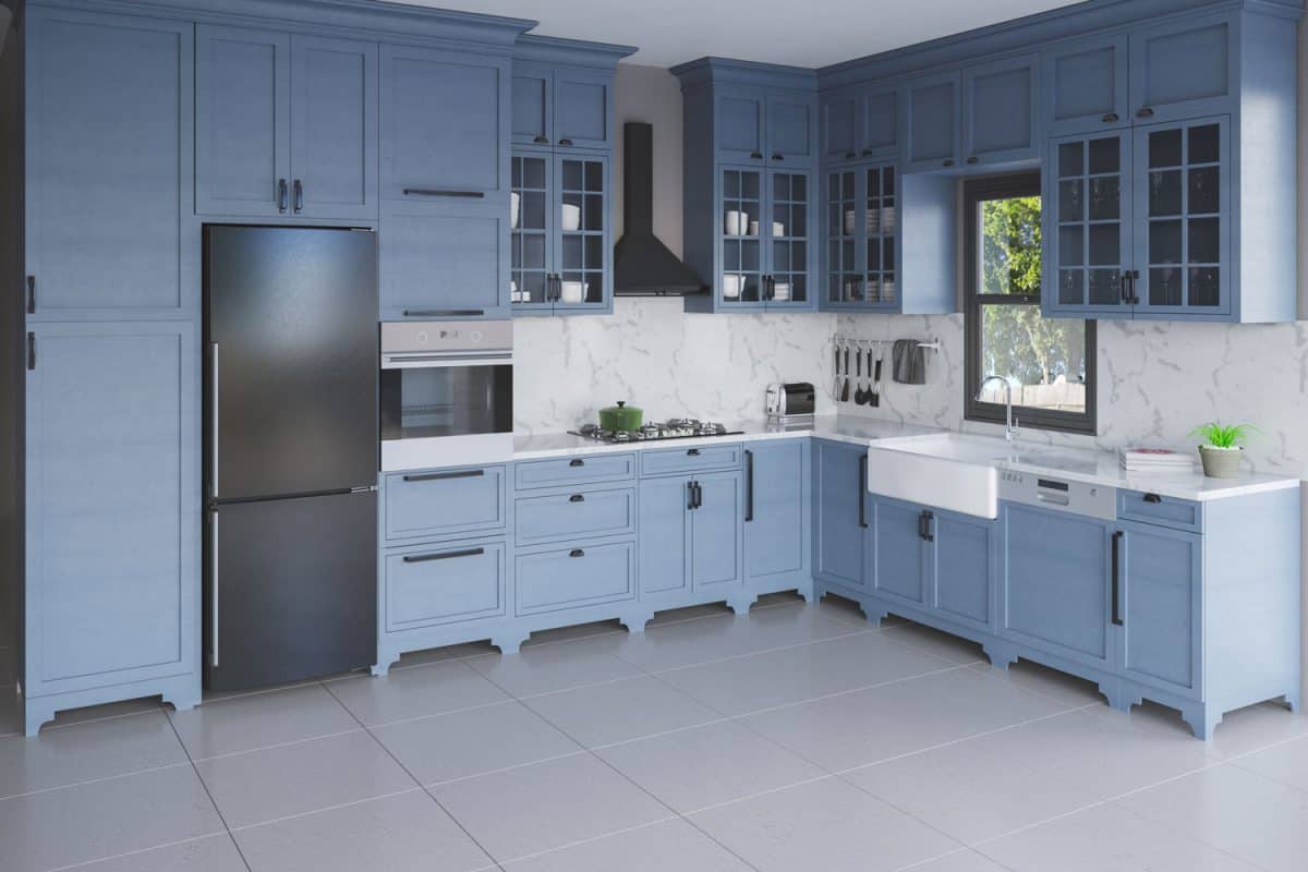 A blue wooden cabinet styled kitchen with a marble backsplash