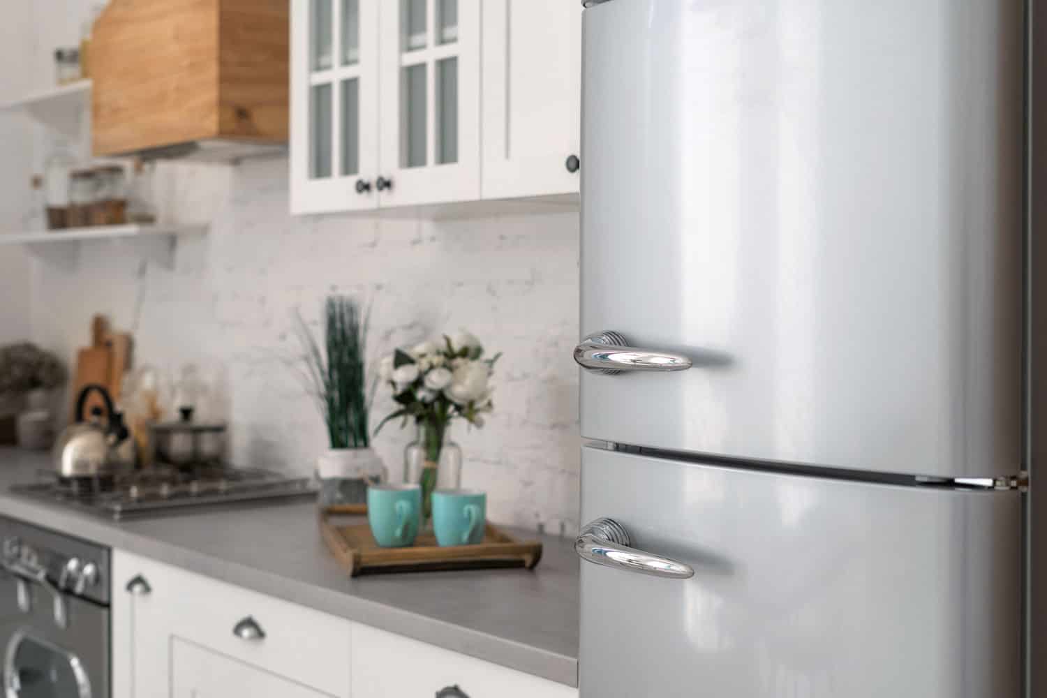 A gray refrigerator at a small modern kitchen