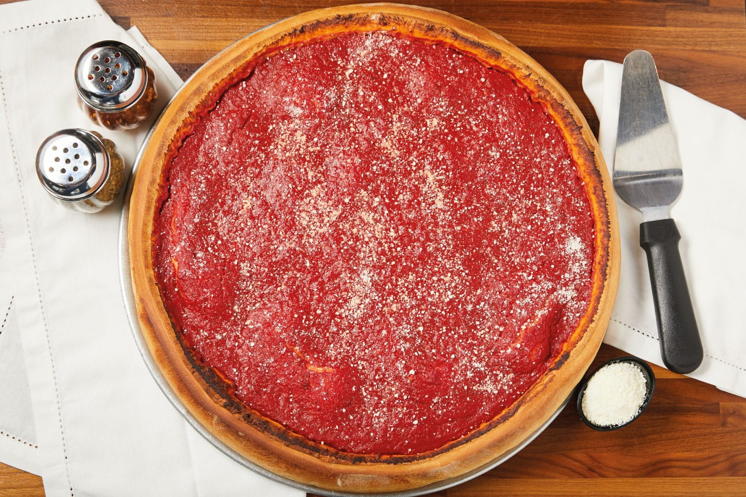 A large and delicious deep dish pizza pie ready to be sliced