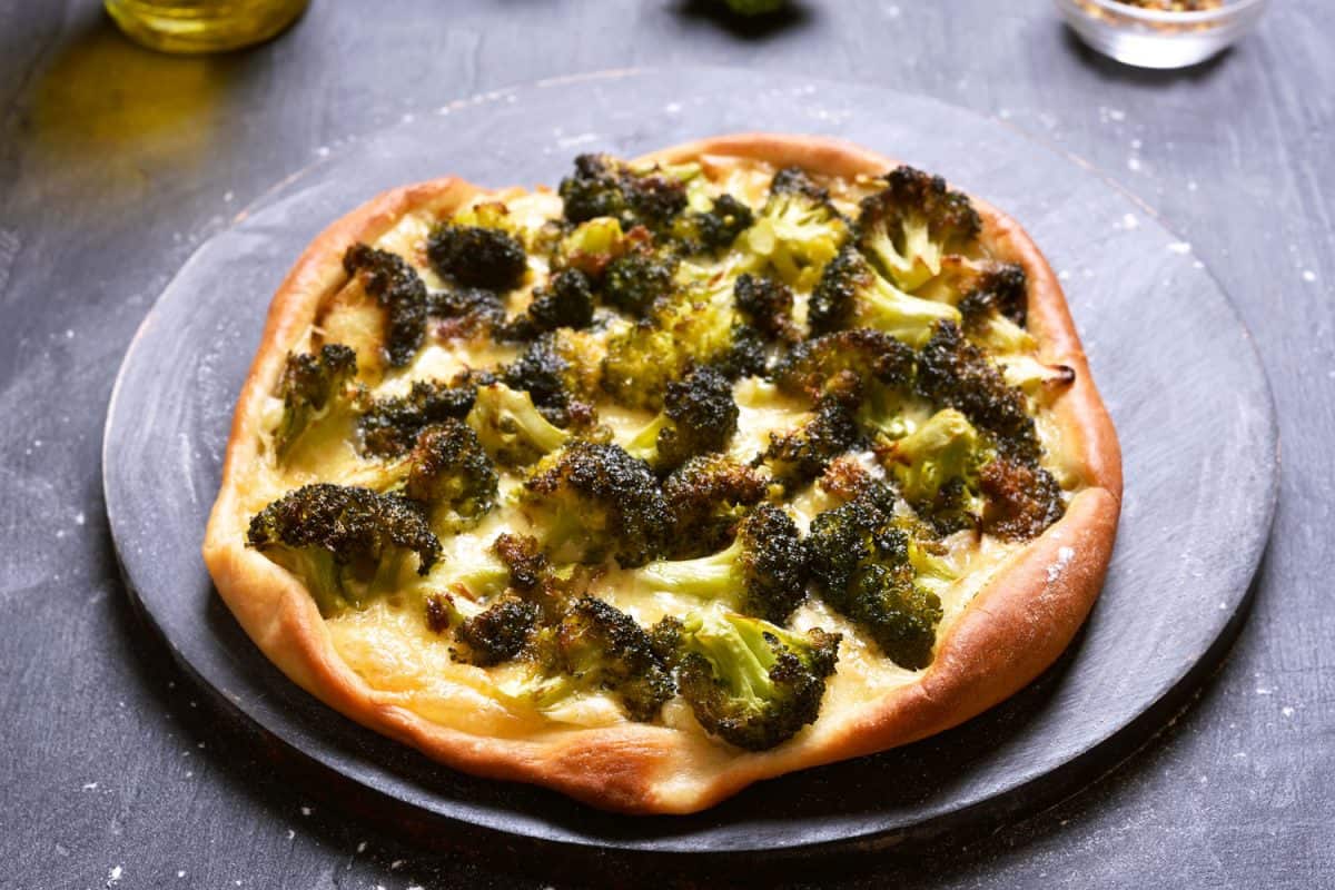 A veggie based pizza with broccoli and cheese