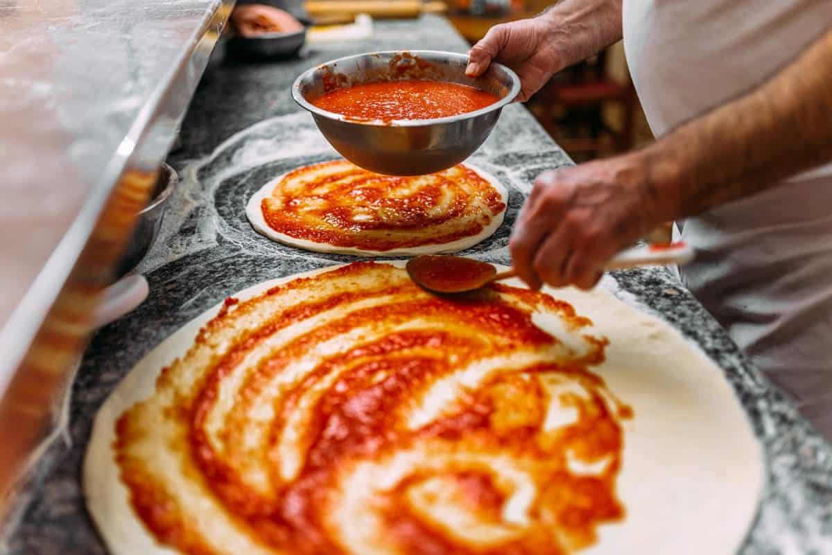 Adding tomato sauce on a pizza dough