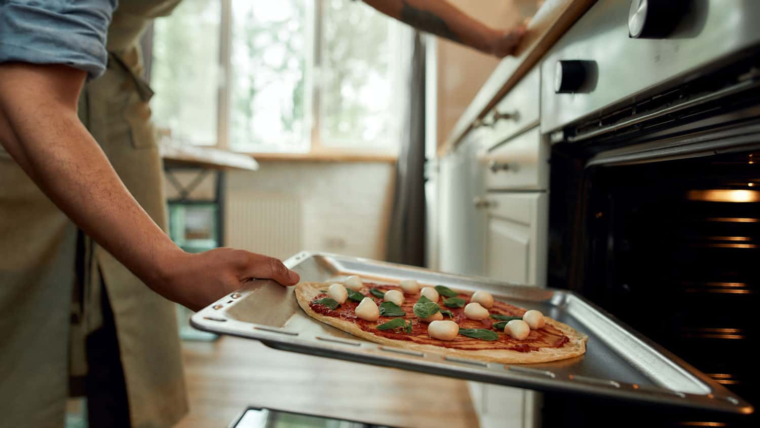 Cropped shot of man, professional cook making pizza at home. 