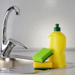 Dishwashing liquid with a sponge on kitchen sink