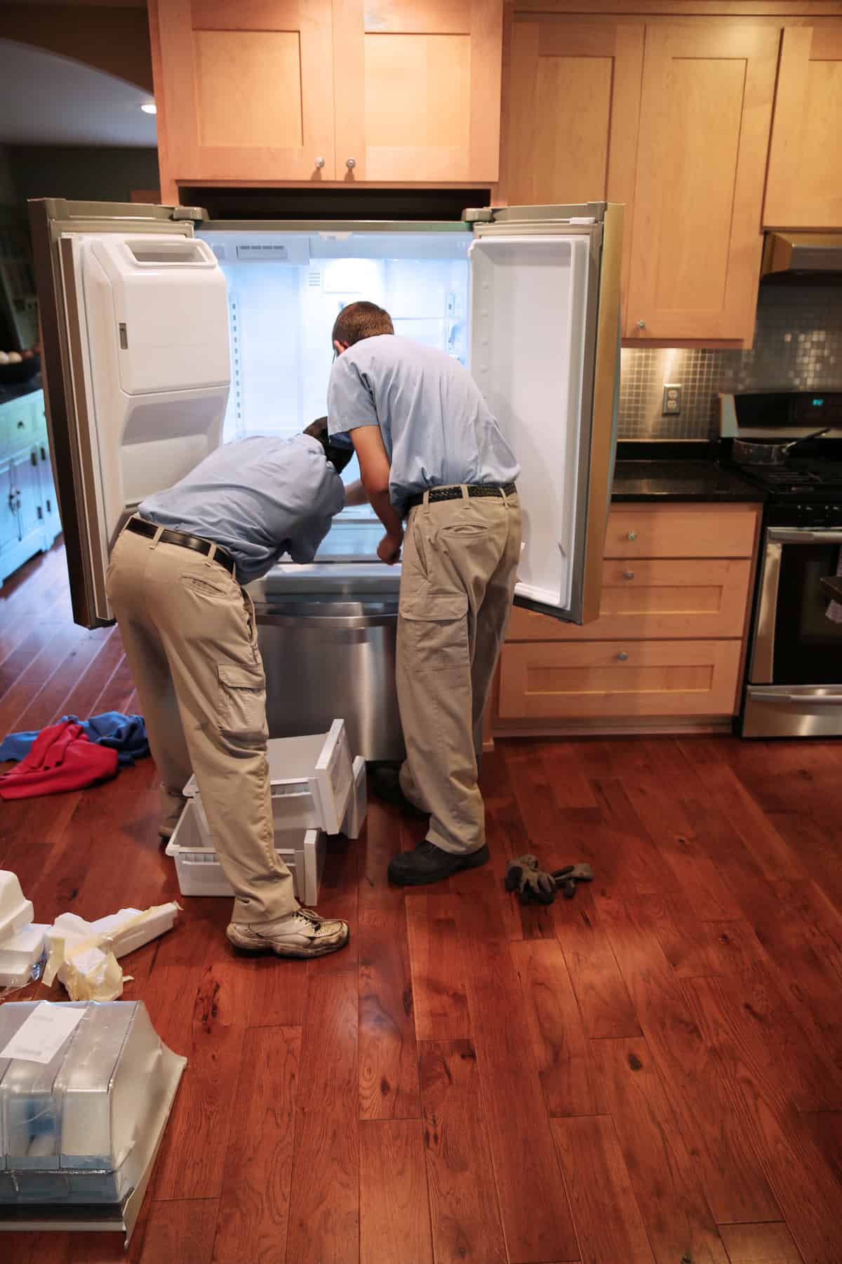 Installing new refrigerator in luxurious kitchen. Open and empty.