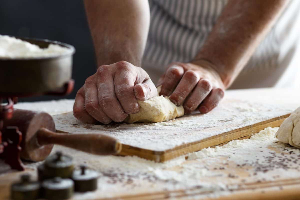 Male baker hands kneading dough