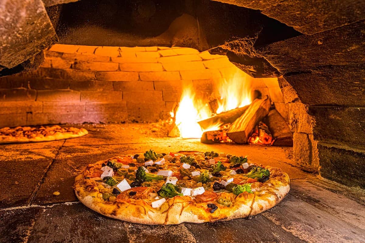 Pizza baked in a rustic wood-fired brick oven