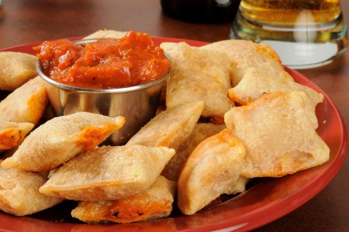 Plate of pizza rolls with marinara sauce and beer