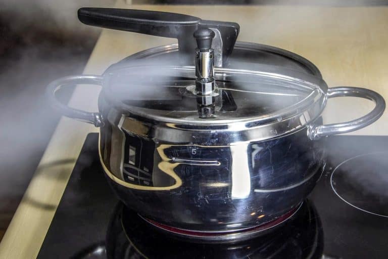 A pressure cooker releasing hot steam, Can You Use A Pressure Cooker On An Electric Stove?