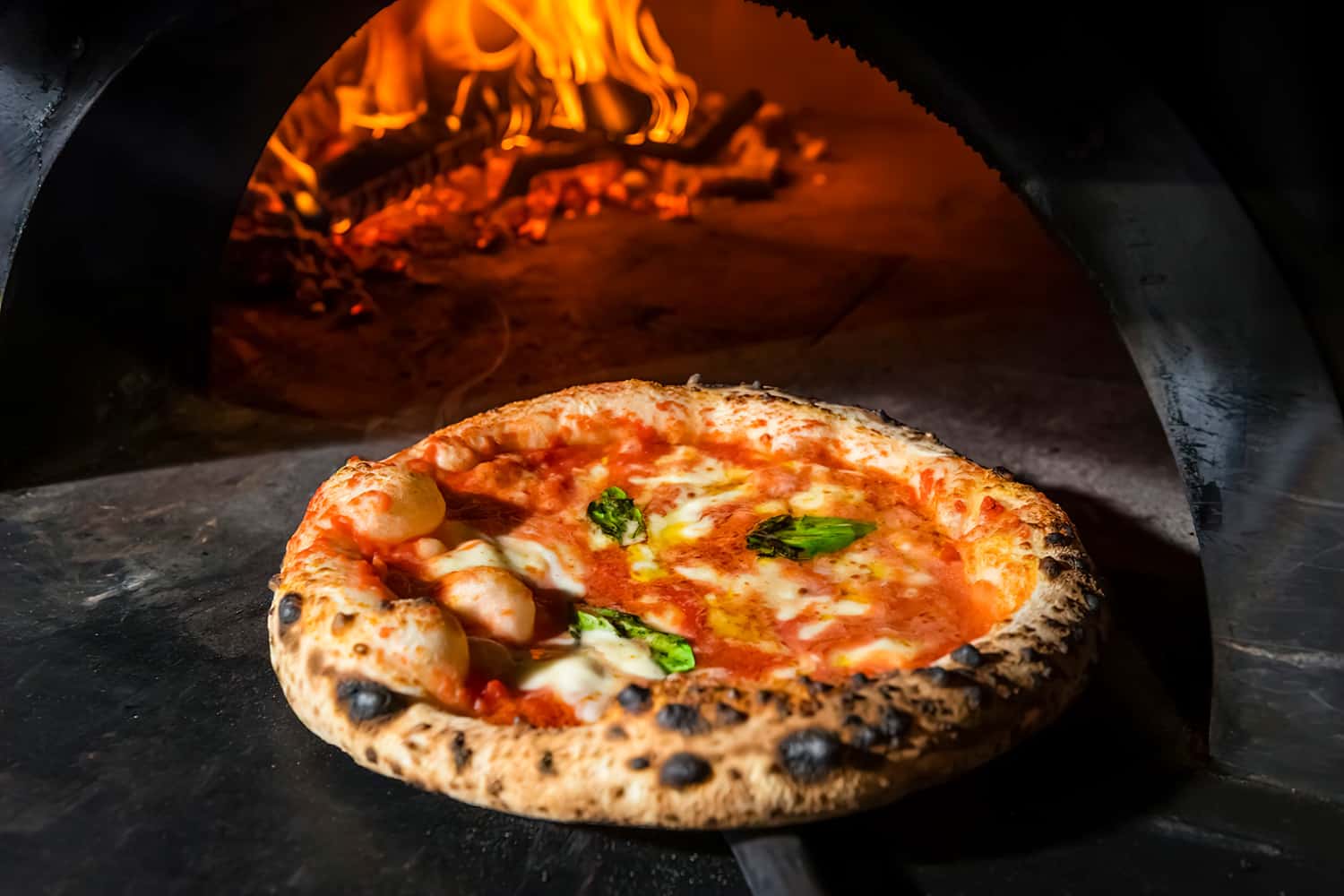Rustic style. Culinary and restaurant concept. A Margarita pizza straight from a wood-fired oven. Close-up, baked in a wood-fired pizza oven.