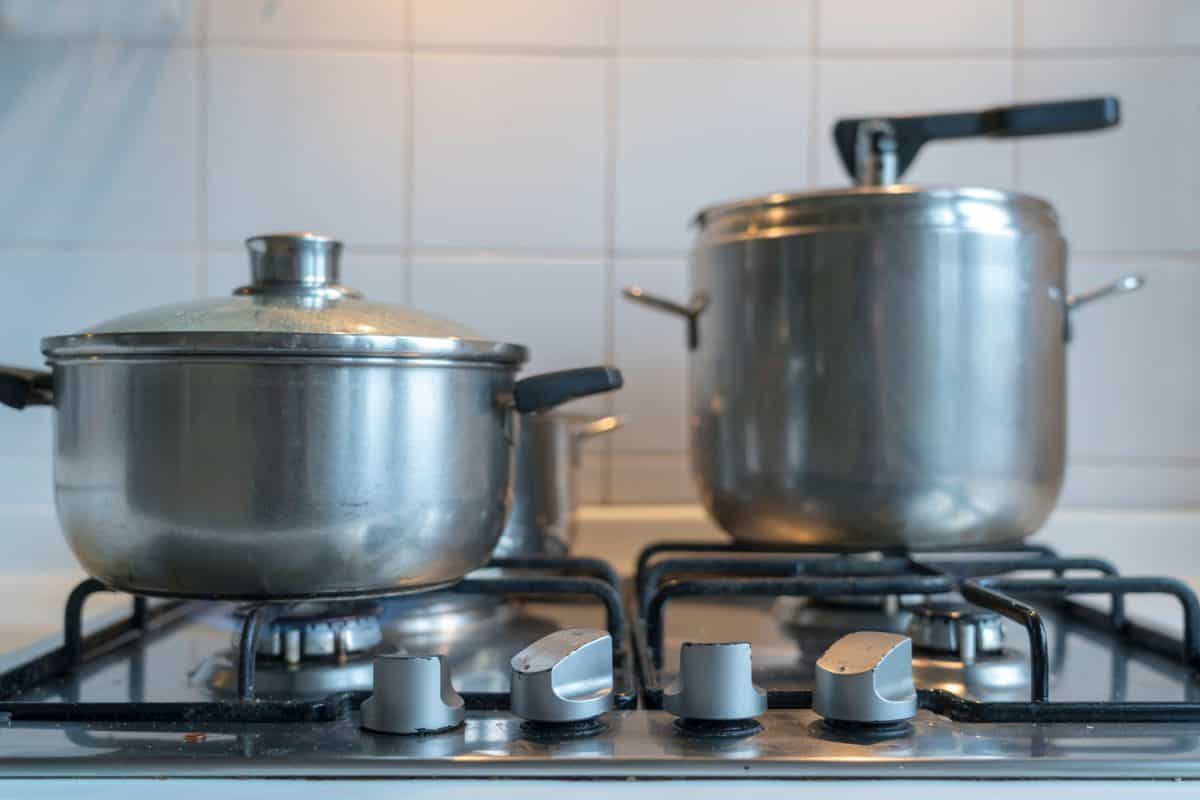 Stainless steel pots and pressure cooker on the cooktop