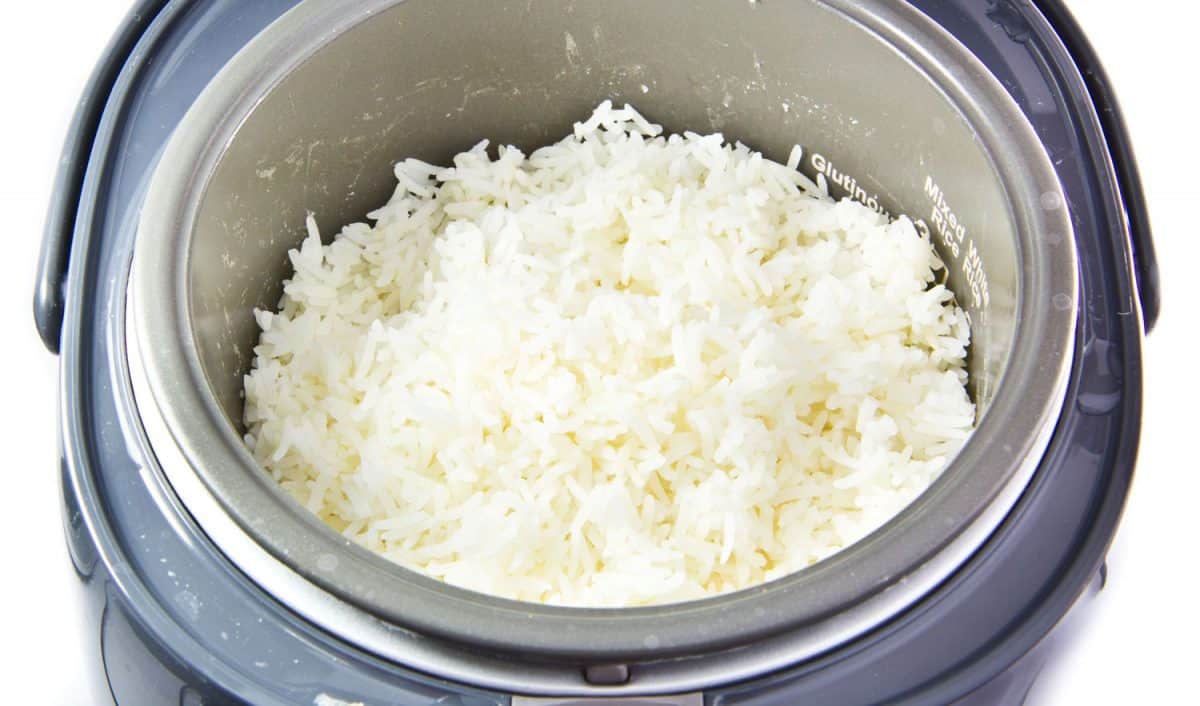 Stream rice in electric rice cooker isolated on a white background