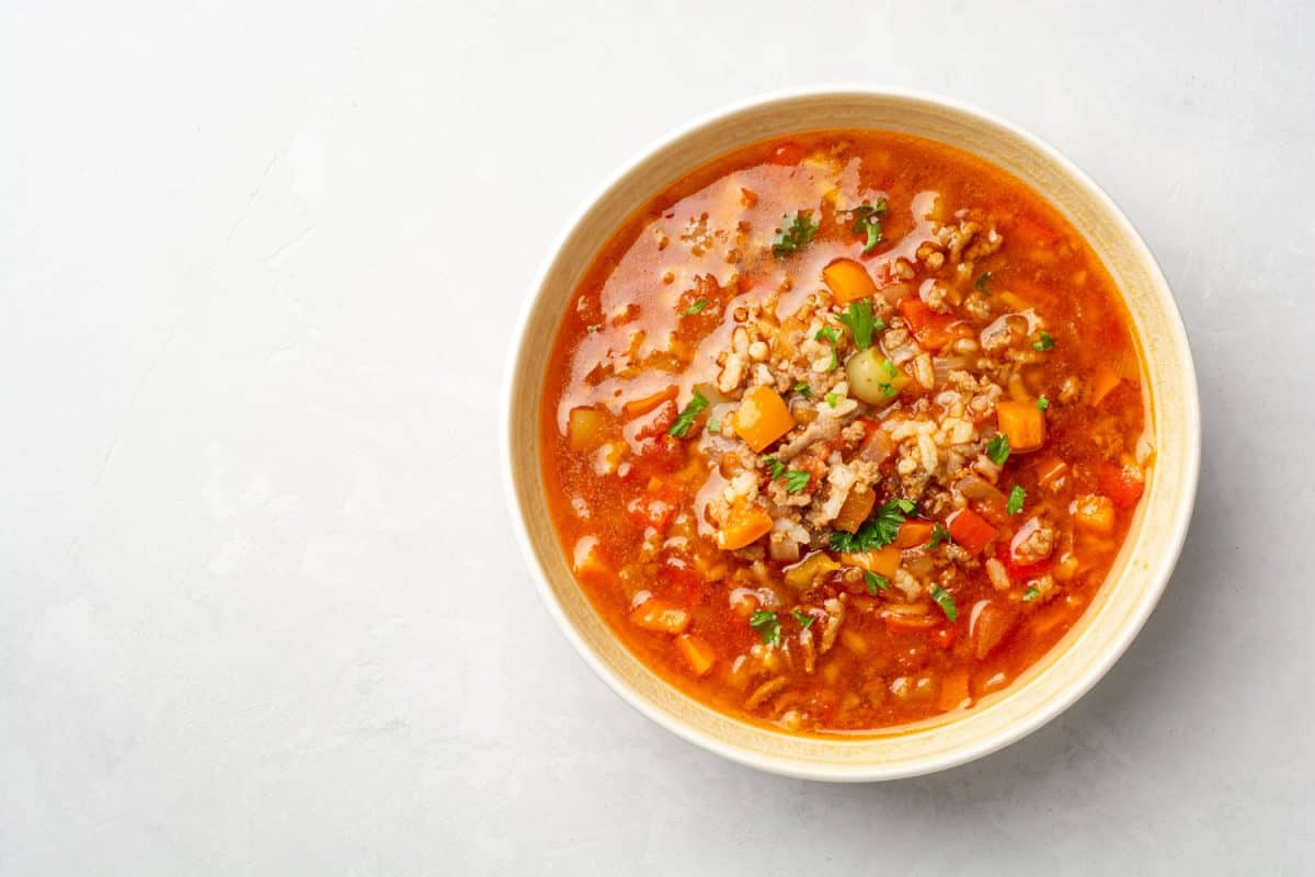 Stuffed pepper soup in bowl on concrete background.
