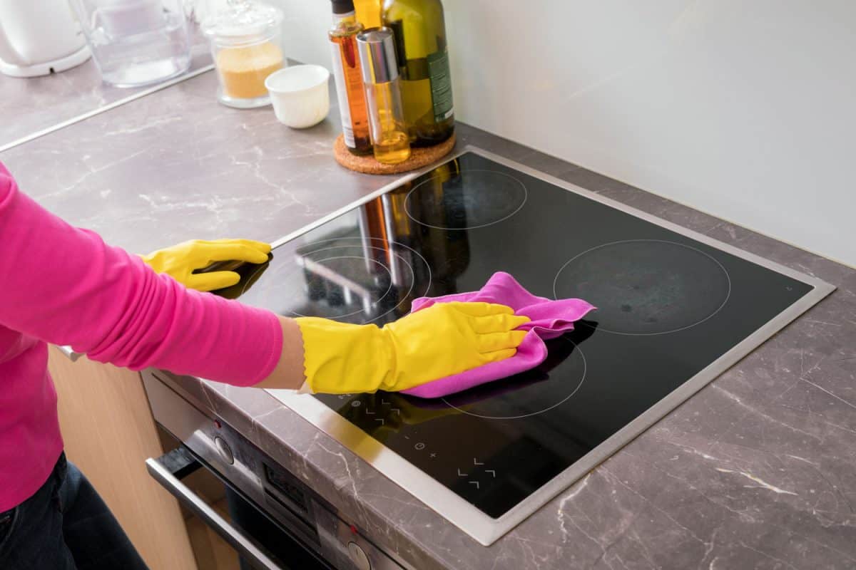 Woman cleaning her glass stove cook top