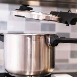 Woman opening the pressure cooker, Pressure Cooker Vs Instant Pot: Which To Choose?