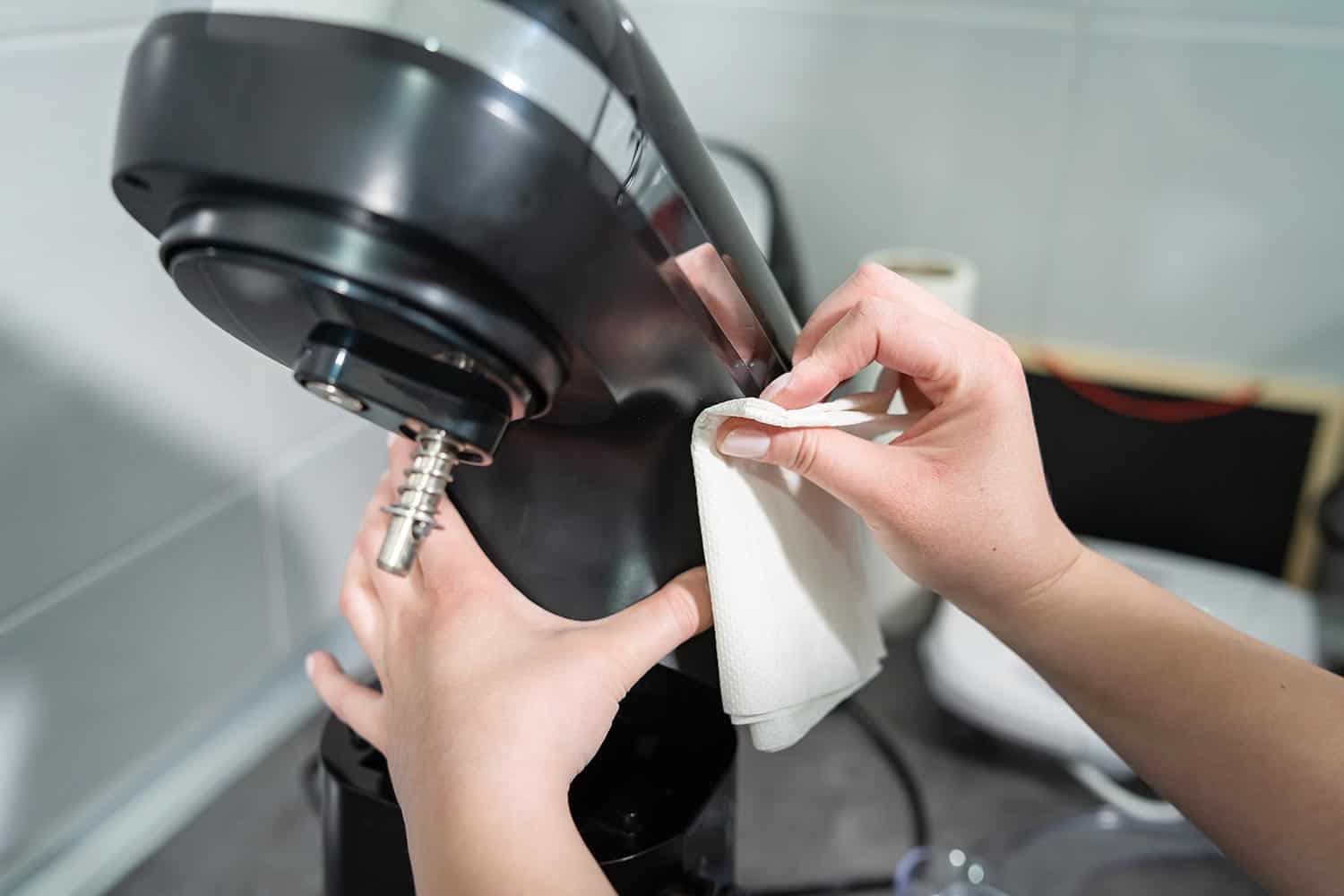 Woman wiping cleaning stand mixer in the kitchen