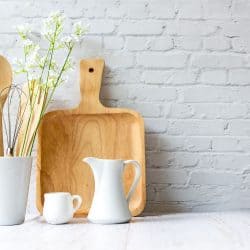 Wooden kitchen utensils in the kitchen with a white brick backsplash, Does Kitchen Backsplash Need Trim Or Edging?