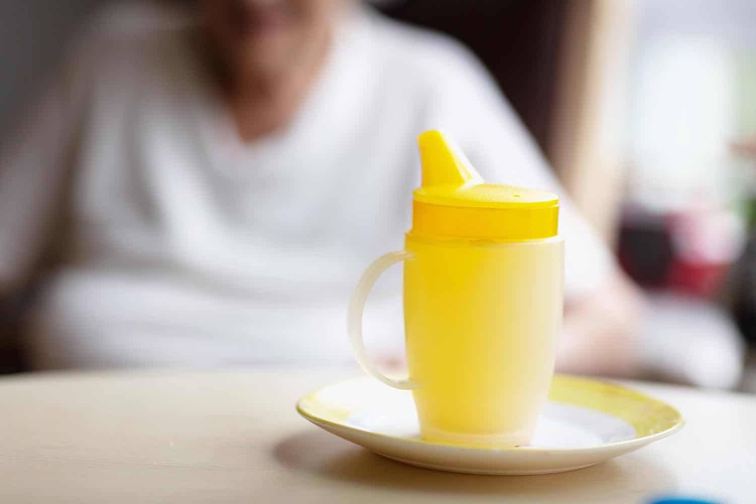 Yellow sippy cup for the use of senior adult