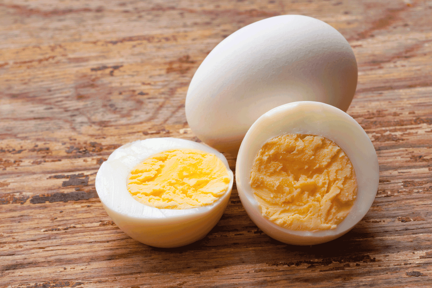 close up photo of hard boiled eggs, one whole other is sliced
