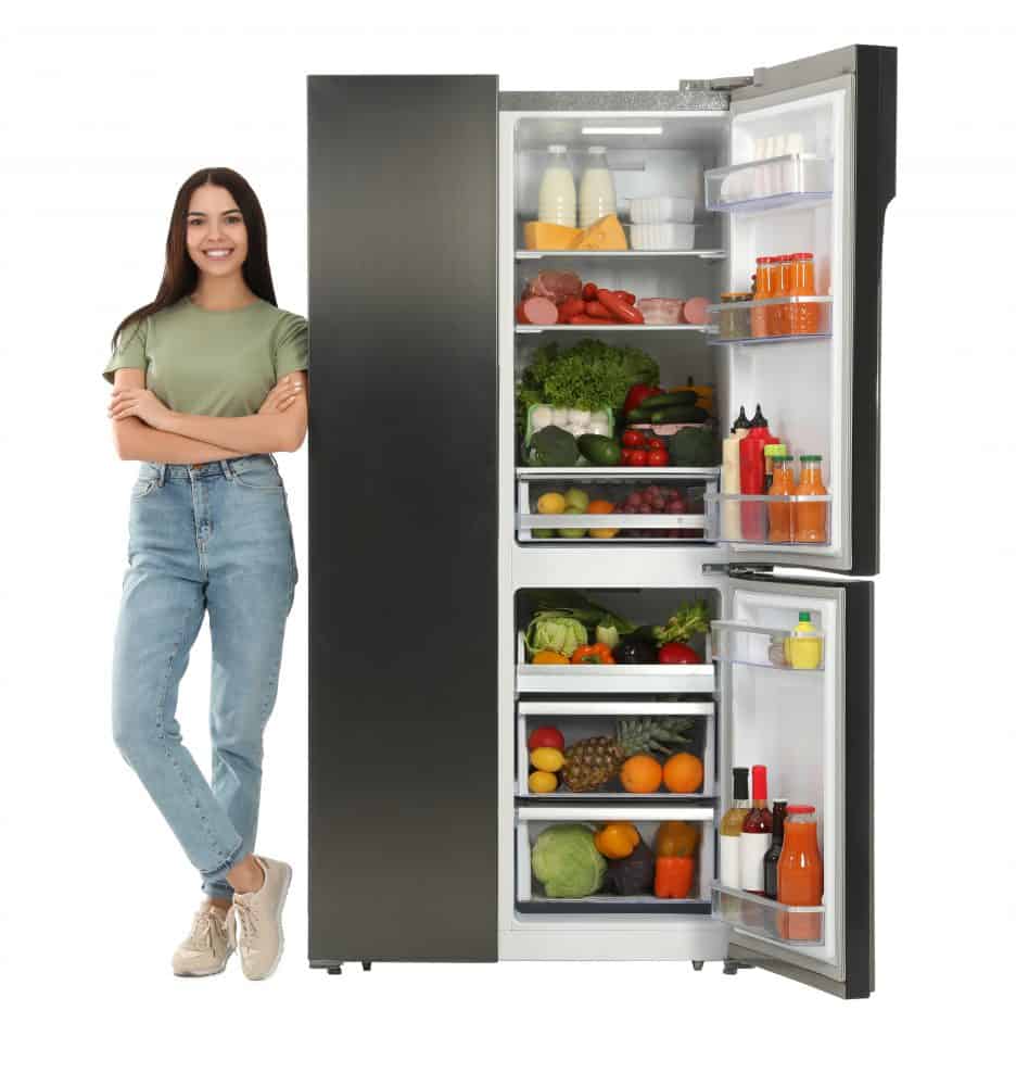 Young woman near open refrigerator on white background