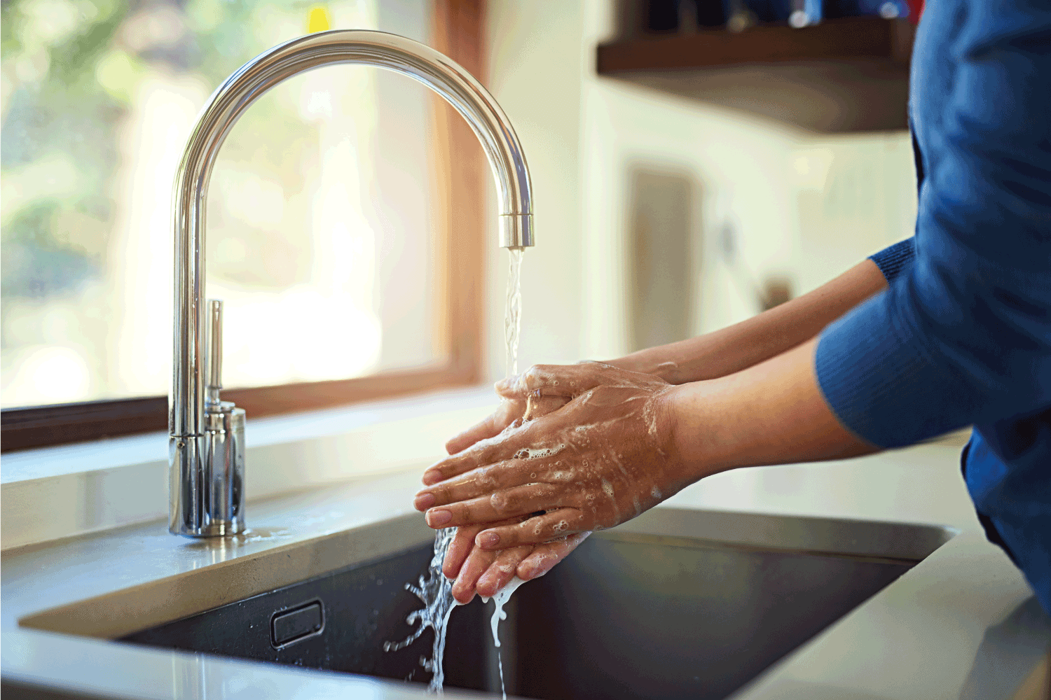  woman washing her hands in the kitchen sink