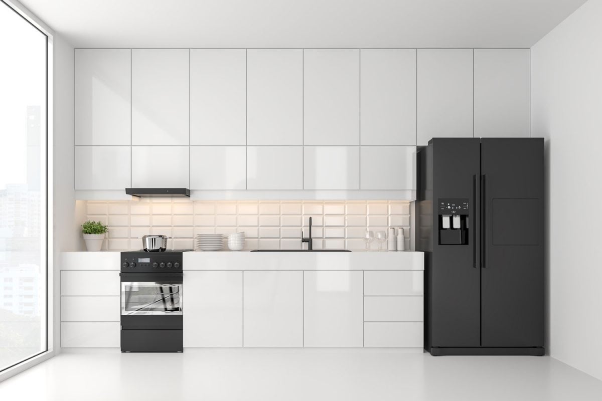 A black refrigerator inside a white kitchen with aluminum cabinets and a cupboards