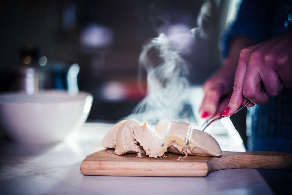 A Chef slicing freshly steamed chicken