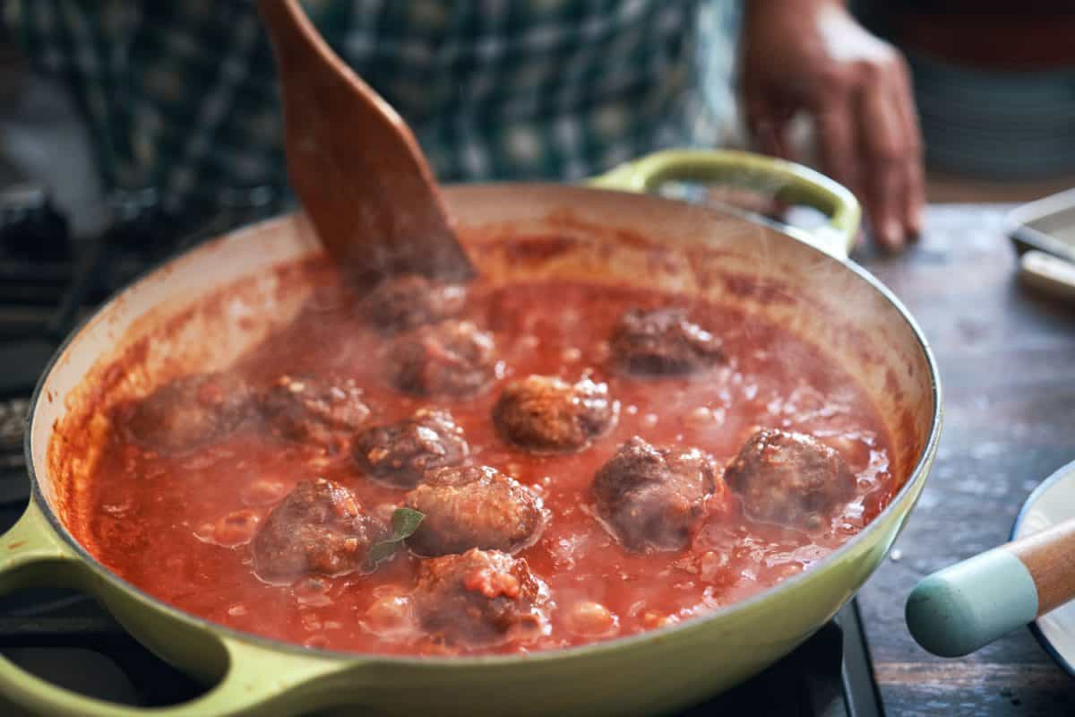 A homecook making Swedish meatballs in a pot