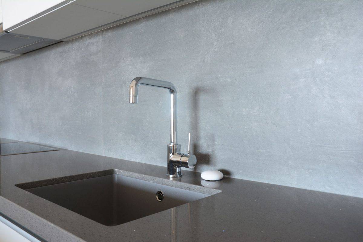 A modern designed kitchen faucet in a kitchen with granite countertop