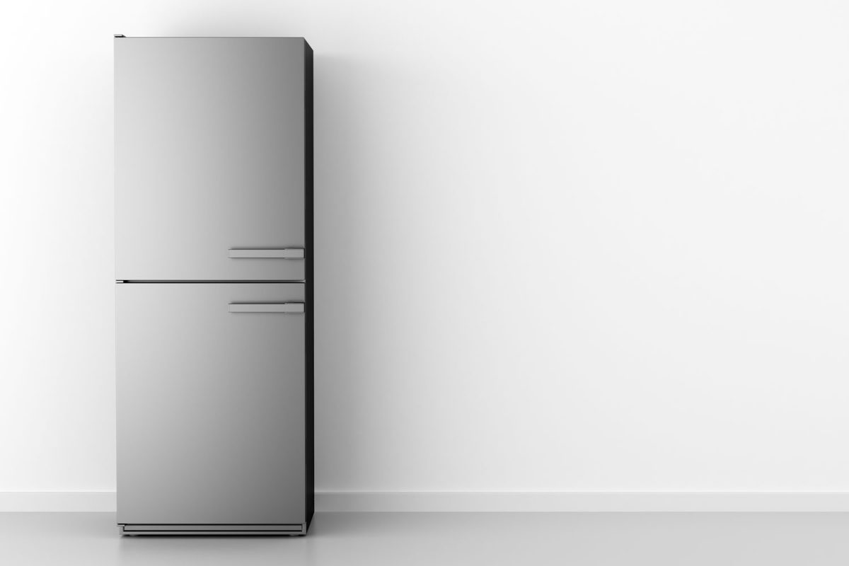 A refrigerator inside an empty kitchen