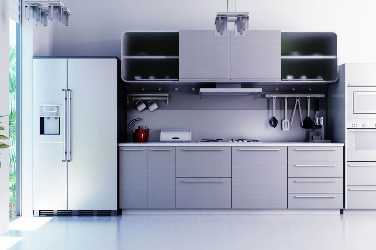 A stainless steel inspired kitchen area with white tile flooring and double door refrigerator