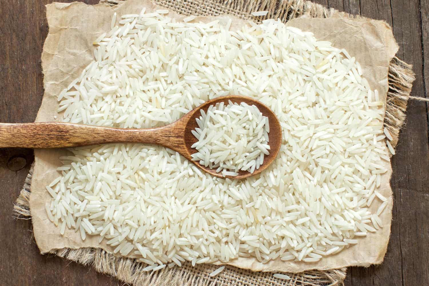 Basmati rice with a spoon on an dark wood