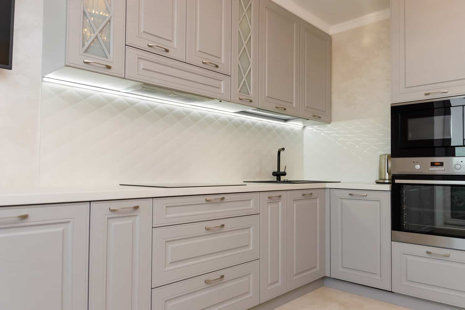 Beautiful interior of a classic kitchen in light gray and white colors with led lighting