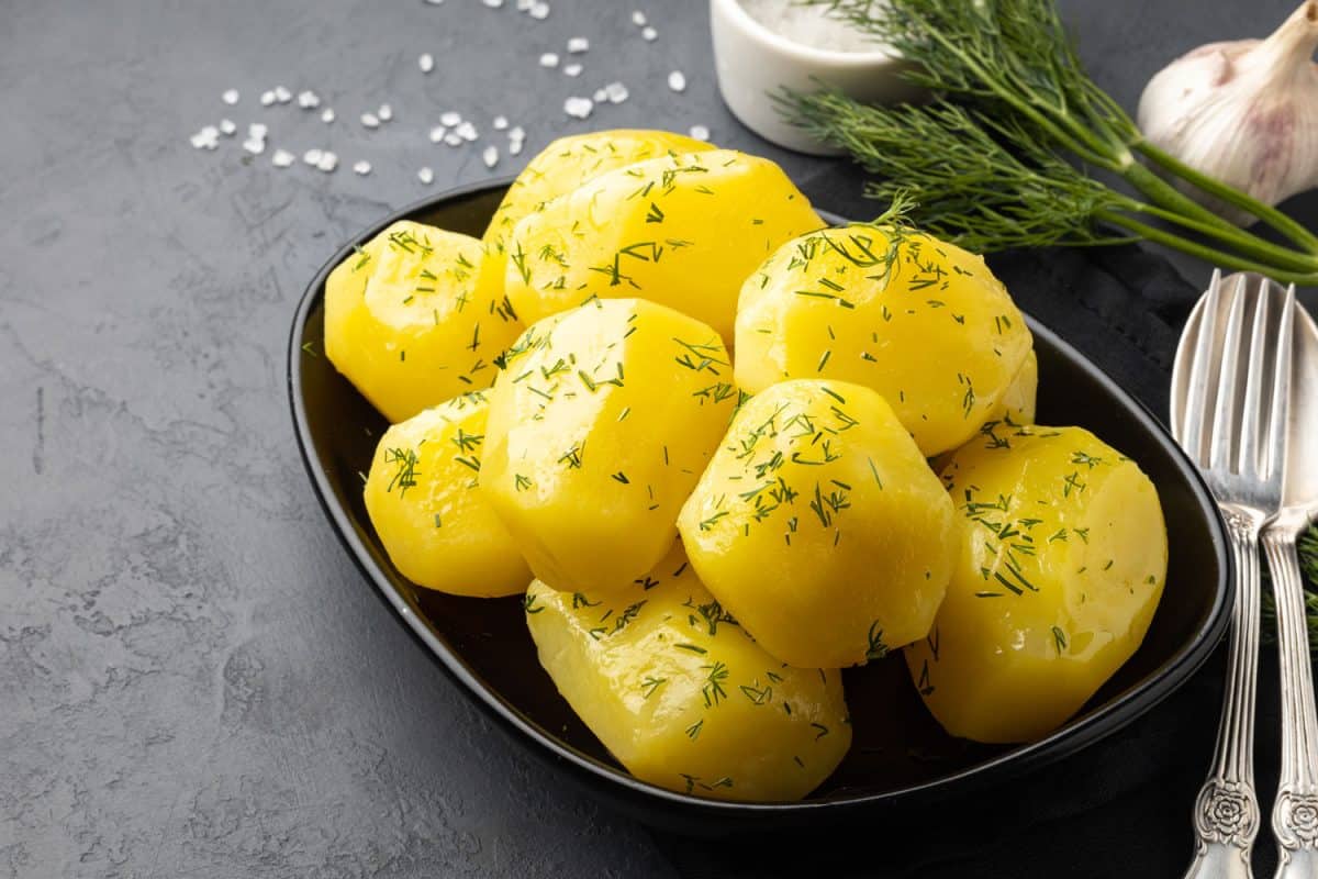 Boiled potatoes drizzled with parsley on a bowl
