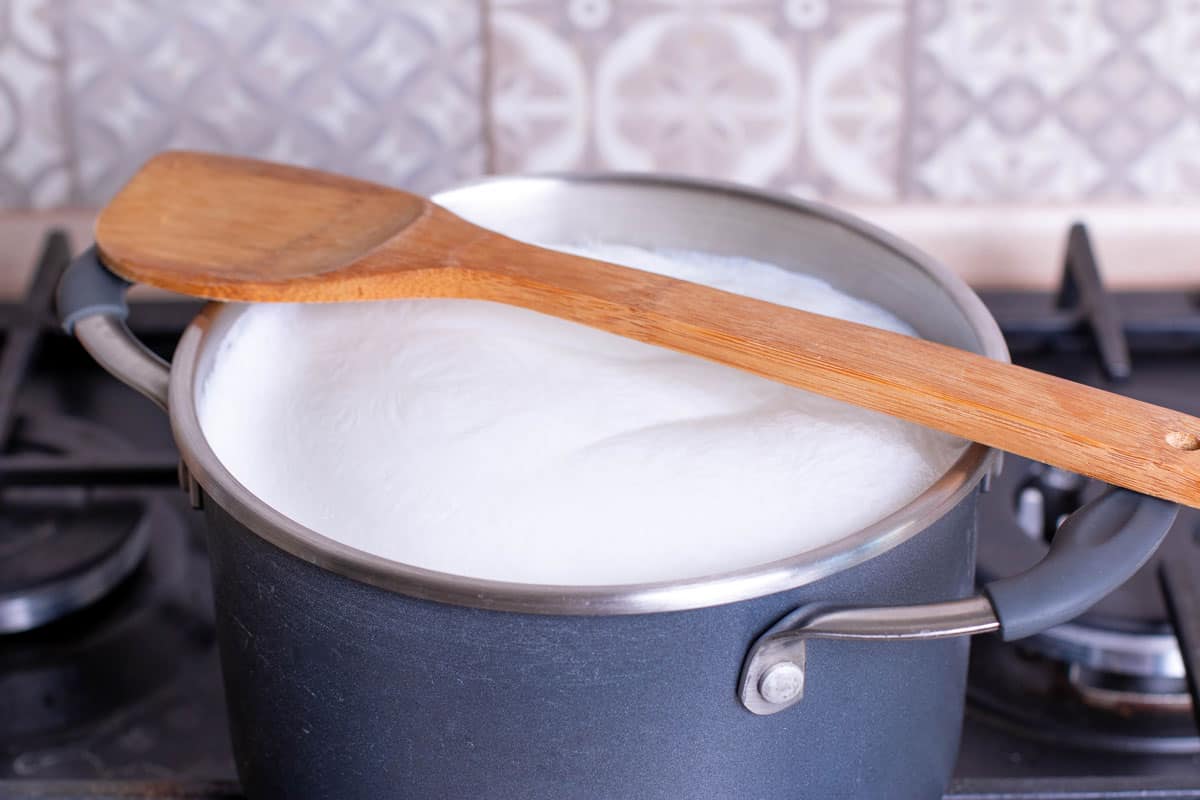 Boiling Milk in Pan with wood spoon as stirir