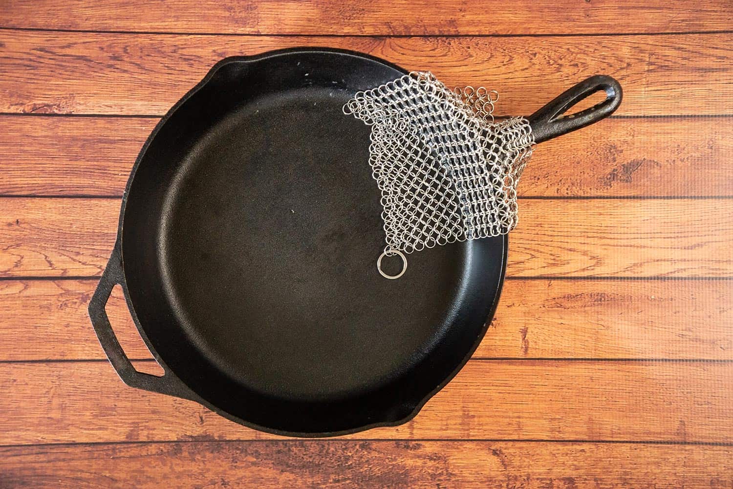 Cast iron cookware with small ring chainmail scrubber