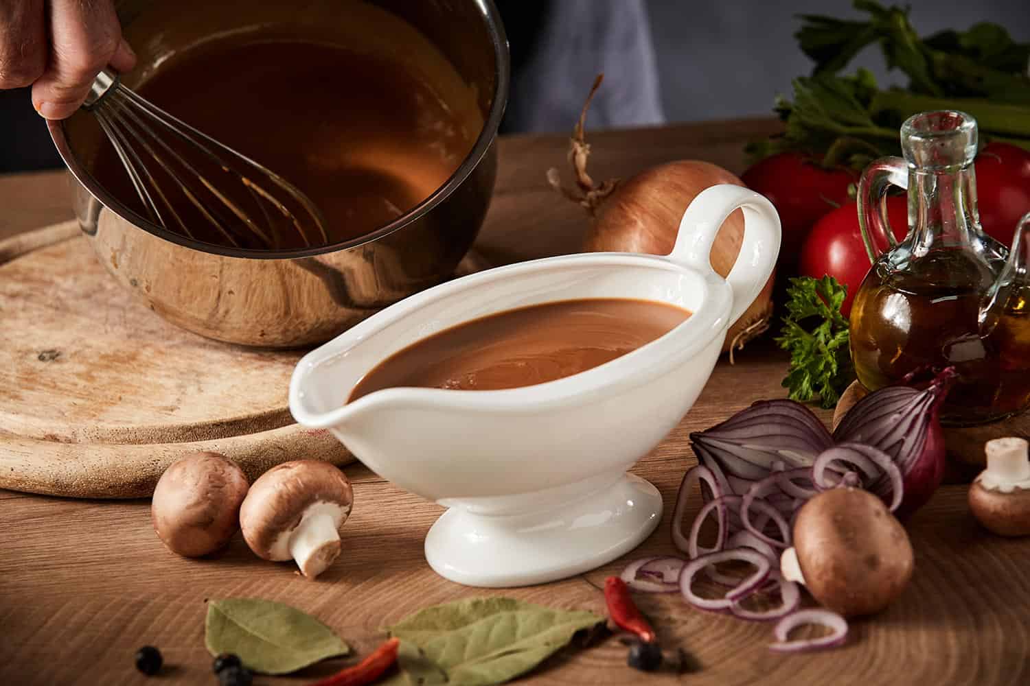 Chef preparing a serving of delicious spicy rich gravy whisking it in a pot