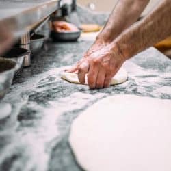 A chef preparing pizza dough, How Long to Knead Pizza Dough