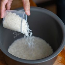 A cook measured the rice with a measuring cup to cook the rice. How Big Is A Rice Cooker Cup?