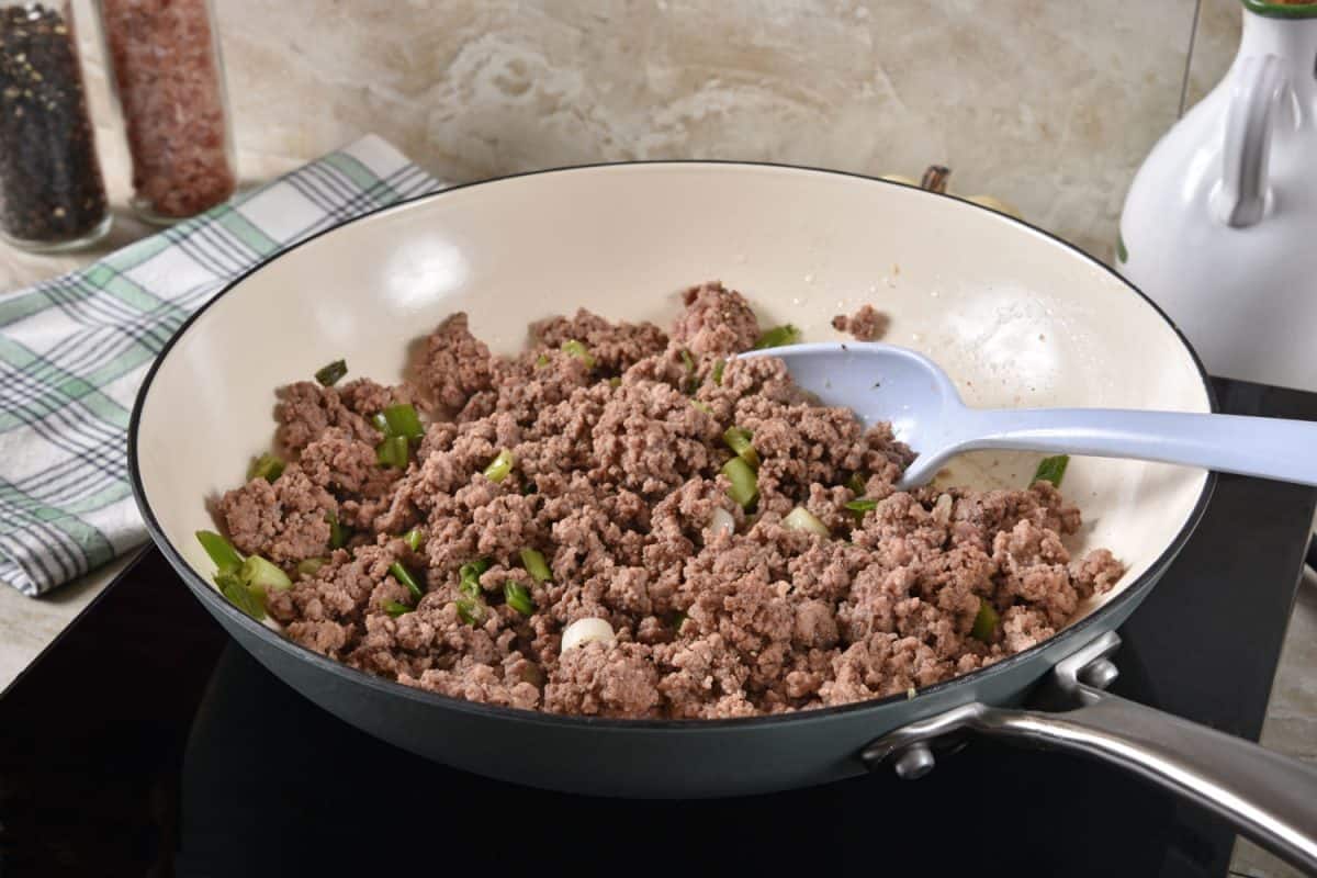 Cooking ground pork in a non stick skillet with spring onions