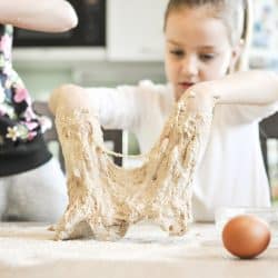 Cute little girls having fun while making a dough for a bread or pizza in a domestic kitchen - Pizza Dough Not Rising - What To Do