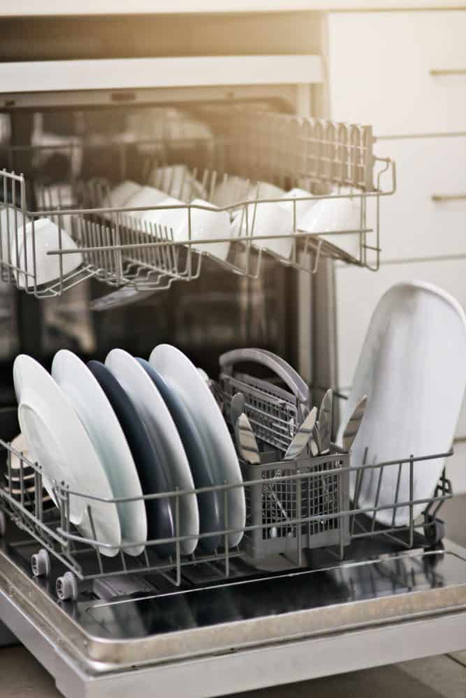 Dozens of plates and cups along with other utensils inside the dishwasher