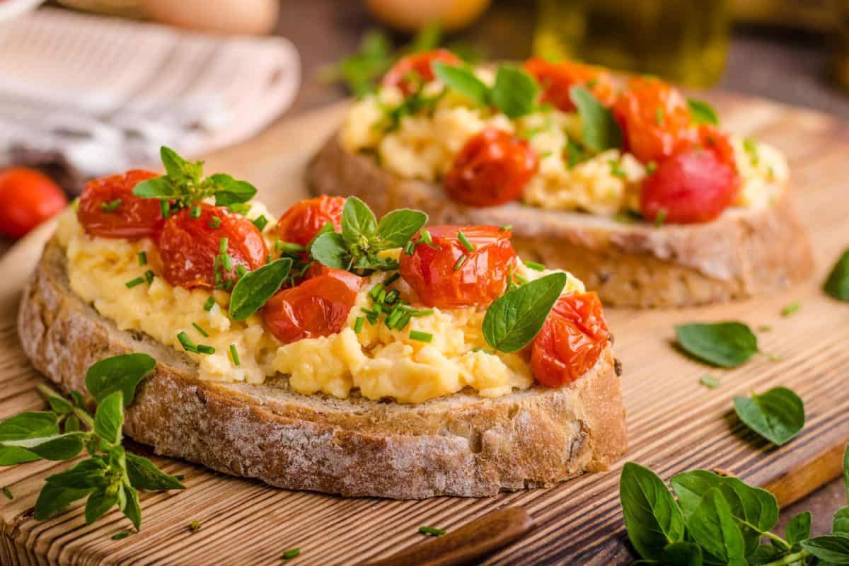 French bread with scrambled eggs and topped with cherry tomatoes