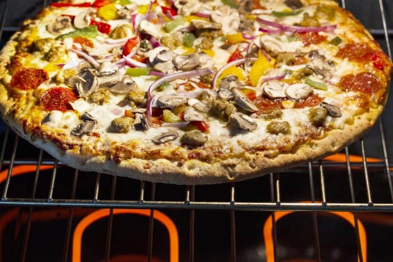 A fresh pizza baking in electric oven with burners glowing hot underneath oven rack, Can You Place Pizza On Oven Rack?