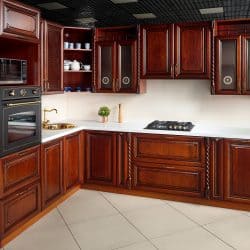 Interior of modern kitchen in classic style with golden elements cherry alder wood cabinetry with built-in appliances electric or induction hob, electric oven stone sink and extractor fan - What Color Floor With Cherry Cabinets