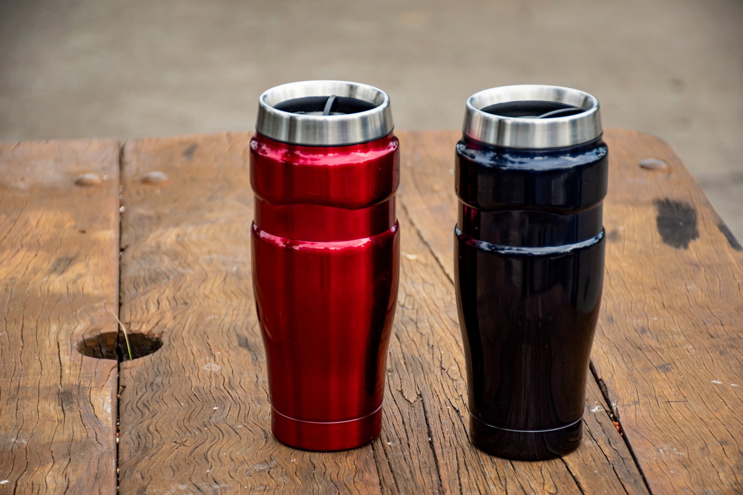 Insulated reusable stainless steel coffee travel tumbler mugs on the wooden table
