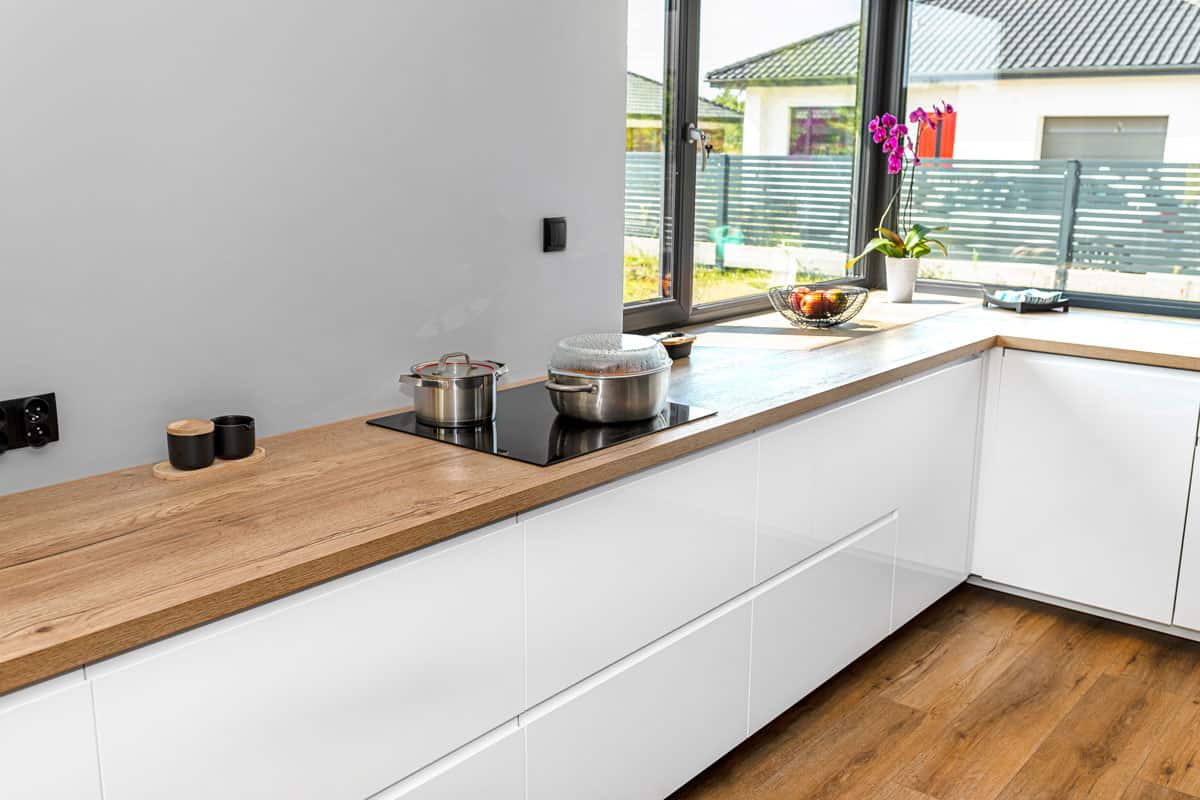 Kitchen worktop on cabinets with metal pots and induction cooker