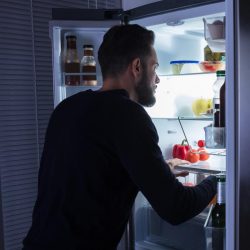 A man looking food kept in refrigerator, Can A Refrigerator Be Stored In Freezing Temperatures?